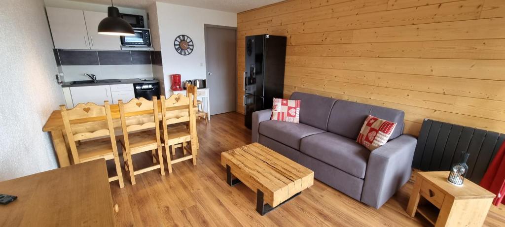 a living room with a couch and a table at Auris les Gentianes station Alpe Huez in Auris