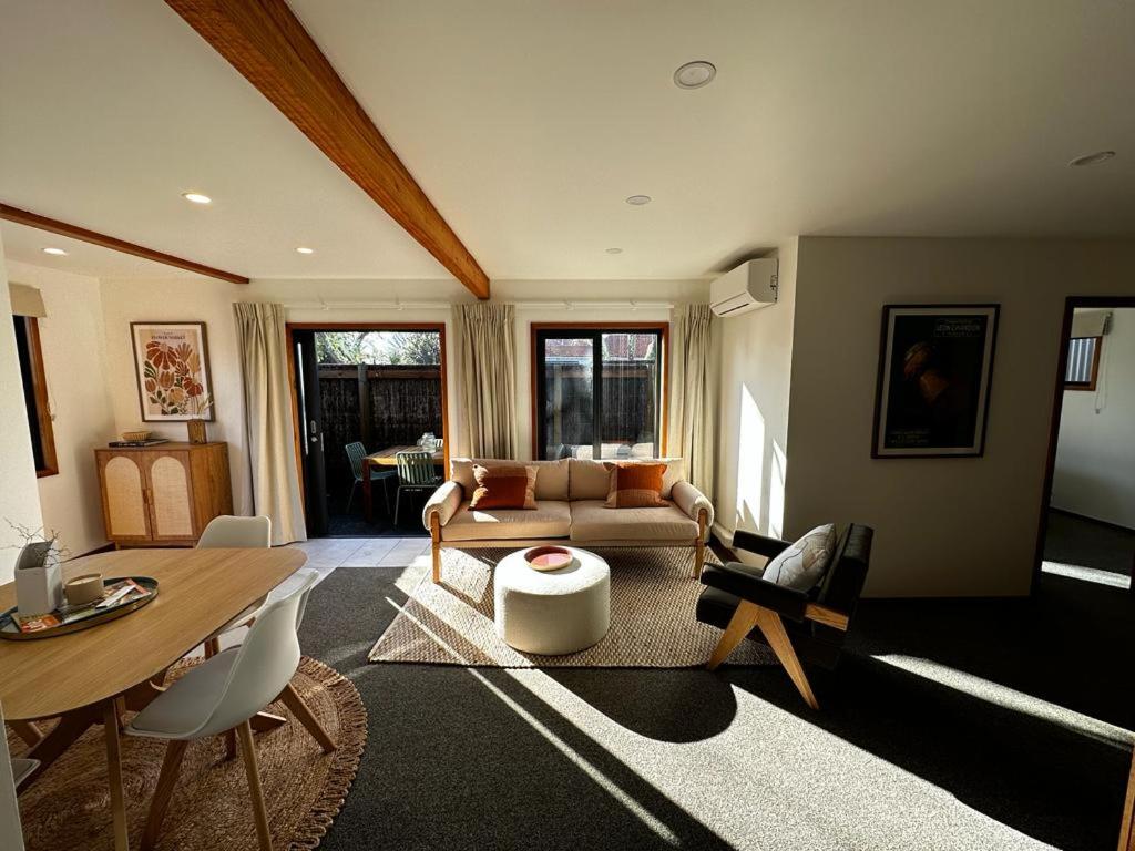 uma sala de estar com uma mesa e um sofá em Woolshed 17 - Self Catering Accommodation em Havelock North