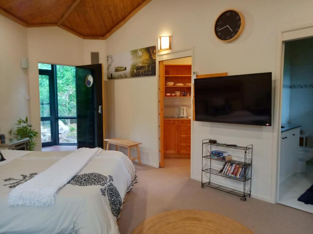 a bedroom with a bed and a flat screen tv at Garden Apartment, self contained, Hunter Valley in Muswellbrook