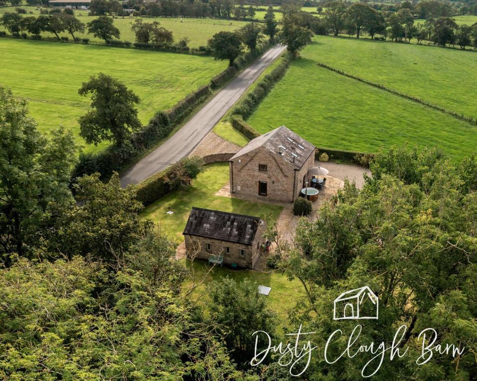an old house in a field next to a road at Dusty Clough Barn in Preston