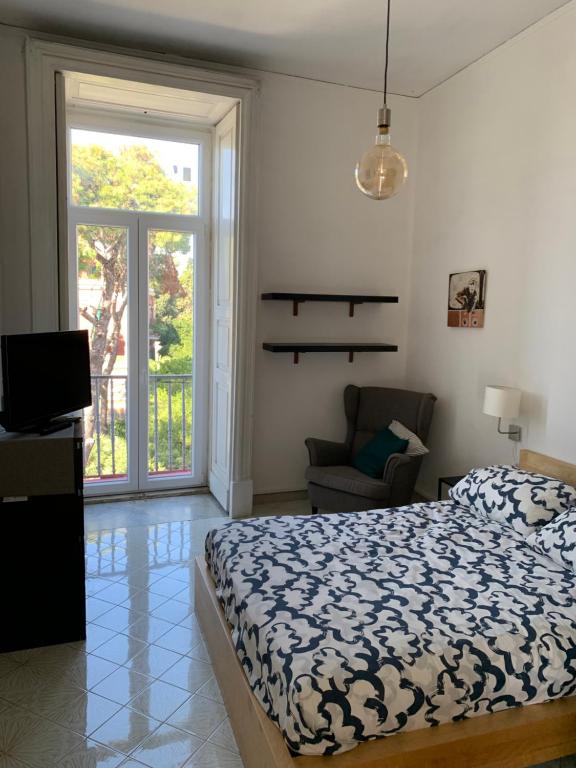 - une chambre avec un lit, une chaise et une fenêtre dans l'établissement Il Poli, à Portici