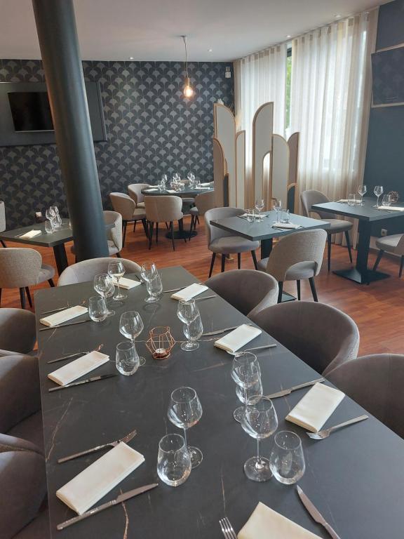 une salle à manger avec des tables, des chaises et des verres à vin dans l'établissement La Table du Pic, à Montverdun