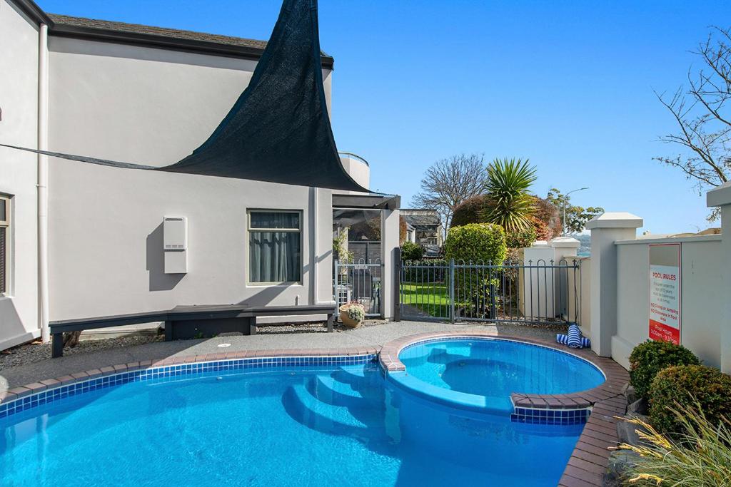 a swimming pool in front of a house at Taupo Central Apartment in Taupo