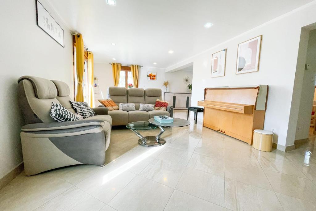 a living room with a couch and a piano at #FW The House of Sunny Gardens in Saint-Ismier