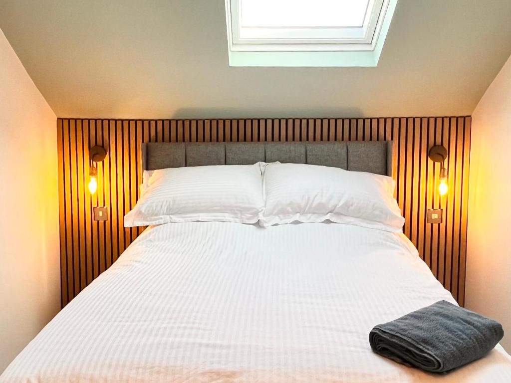 a bedroom with a bed with a black pillow on it at Boutique rooms by Crosby beach in Crosby