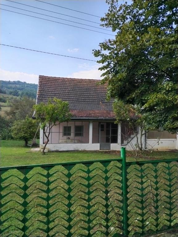 ein Haus mit einem grünen Zaun davor in der Unterkunft Vikendica Sibnica in Blace