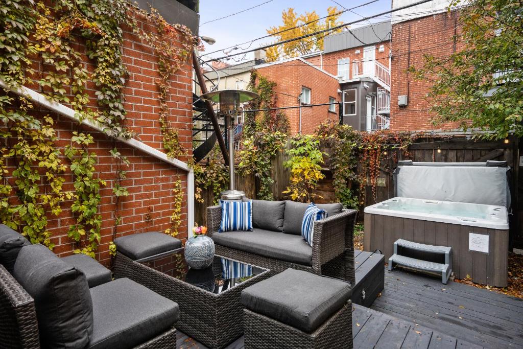 a patio with a hot tub and a couch and chairs at Le Saint Christophe- Centre Ville in Montreal