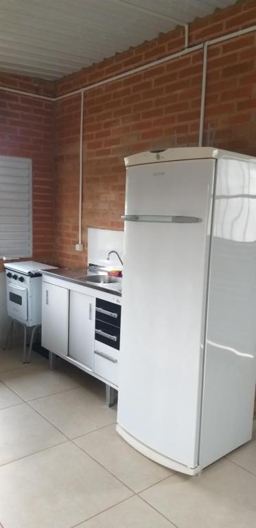 a kitchen with a white refrigerator in a room at Quarto aconchegante Barão Geraldo in Campinas