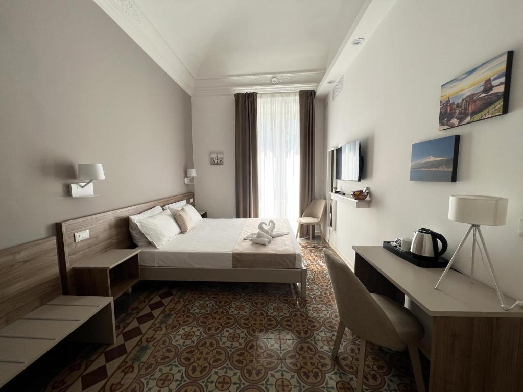 Habitación de hotel con cama y escritorio en Nove Volte B&B, en Catania