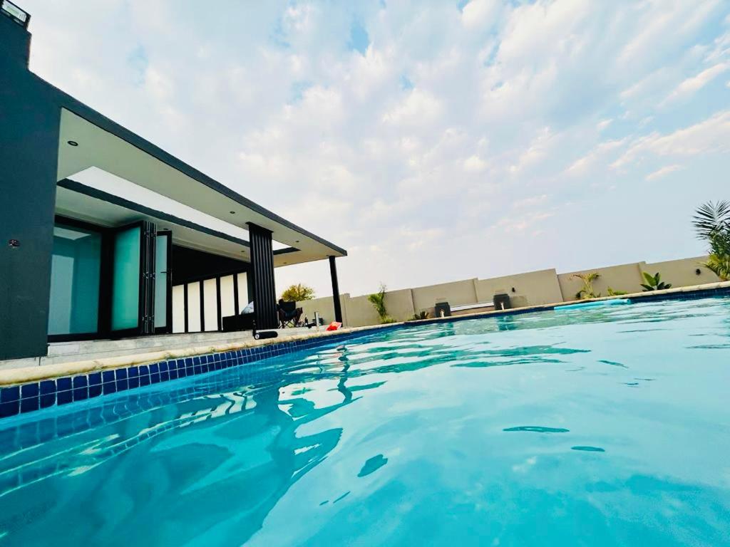 a swimming pool in front of a house at Maison De luxe in Thohoyandou
