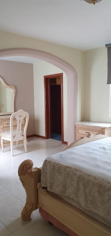 een slaapkamer met een bed en een tafel en stoelen bij hermosa habitacion en casa residencial in Guadalajara