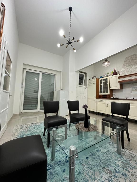 een woonkamer met stoelen en een glazen tafel bij Apartment Monte in Sarajevo