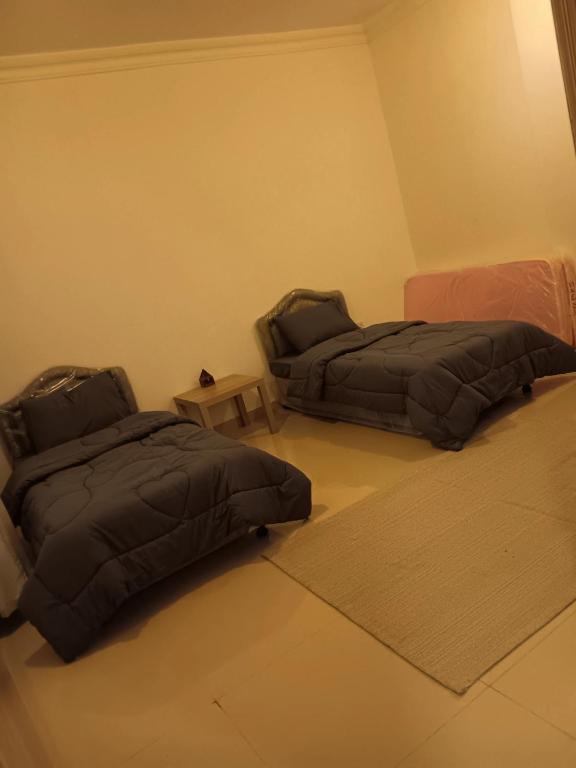 een woonkamer met 2 bedden en een bank bij Kayan apartment1 in Fatḩ Āl Bū Sa‘īd
