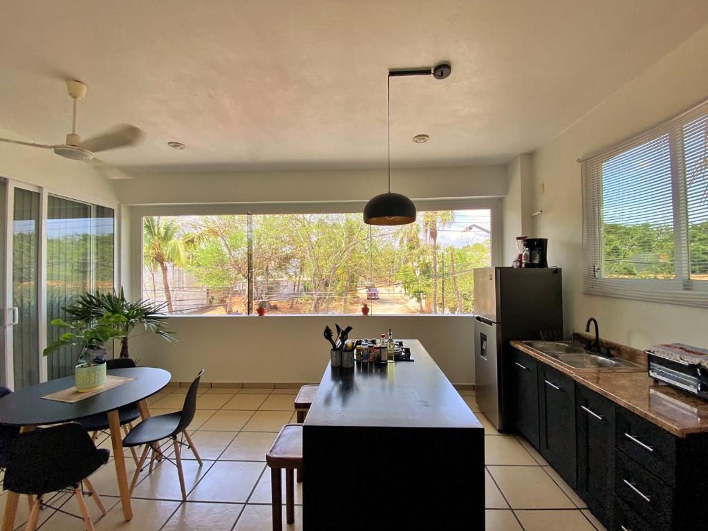 a kitchen with a table and a large window at Edificio Teocalli, Bacocho Puerto Escondido in Puerto Escondido