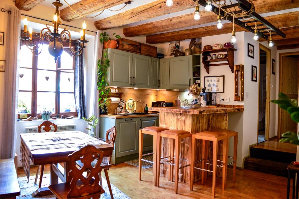 a kitchen with green cabinets and a table with stools at Chaud'Vin in Kaysersberg