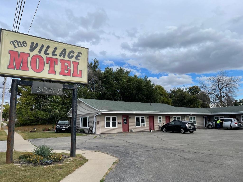 un panneau indiquant un village de motel dans un parking dans l'établissement The Village Motel, à Steamboat Rock