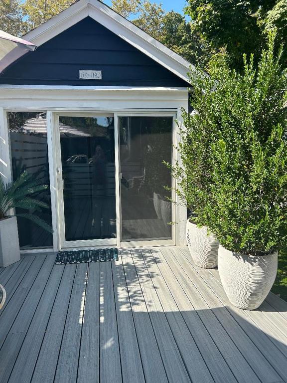 Hotel Adorable 1 bedroom cottage, a porch with two potted plants on a house at Adorable 1 bedroom cottage in Forest Hills