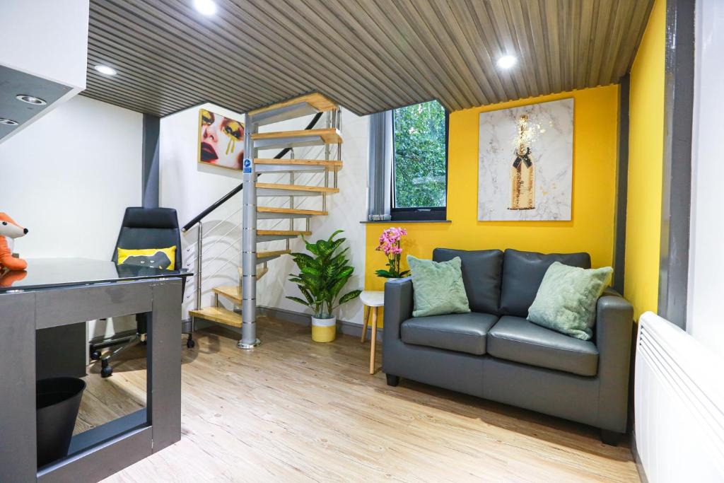 a living room with a couch and a desk at A102 Cheery Bright Loft in Coventry