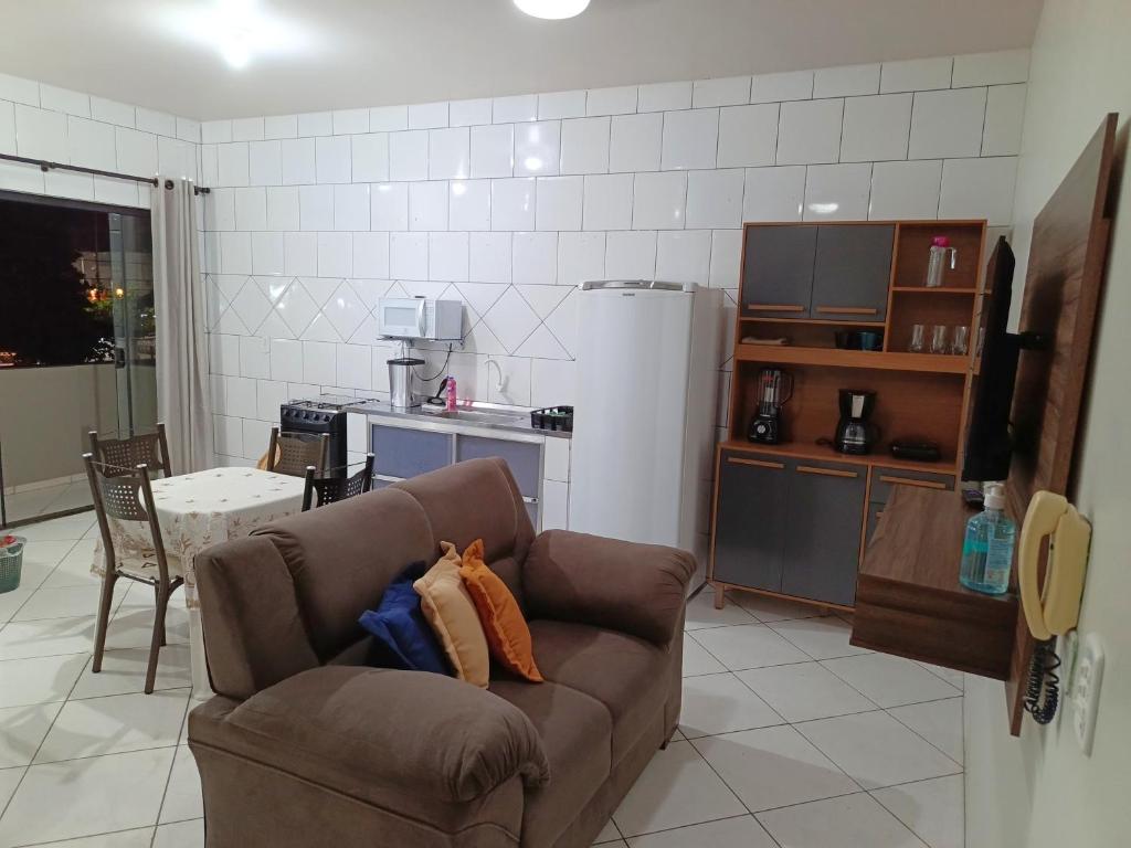 a living room with a couch and a kitchen at Lindo Apto102 em Primavera do Leste in Primavera do Leste