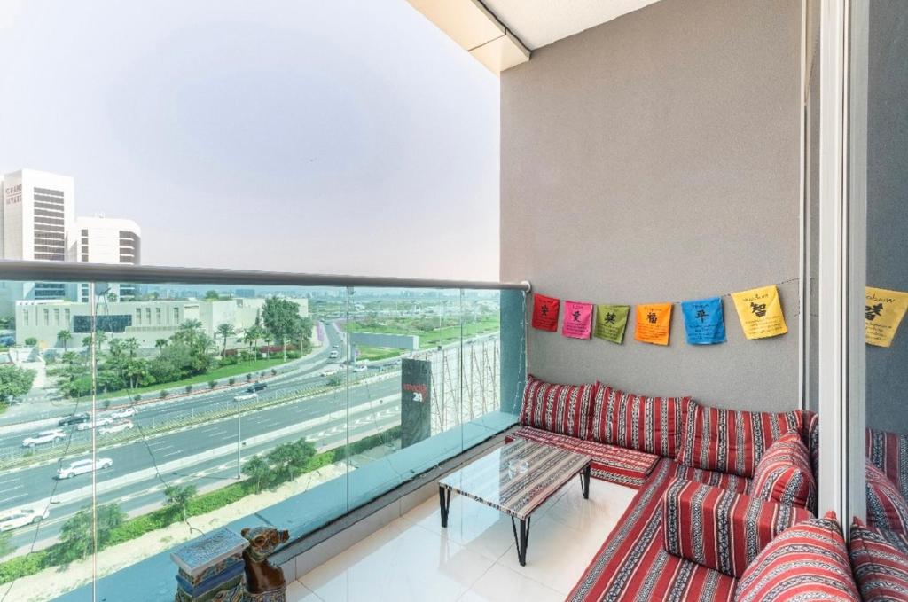 a living room with a couch and a large window at Bright & Cozy, Near Metro & Downtown, Pool, Gym in Dubai