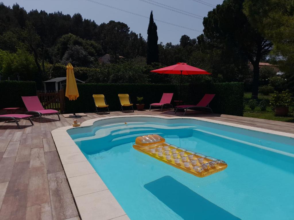 einen Pool mit Stühlen und einem Sonnenschirm in der Unterkunft La Micalene in Trans-en-Provence