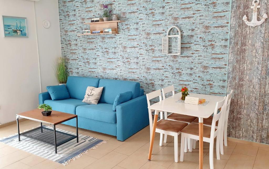 a living room with a blue couch and a table at Apartments Epulon in Pula