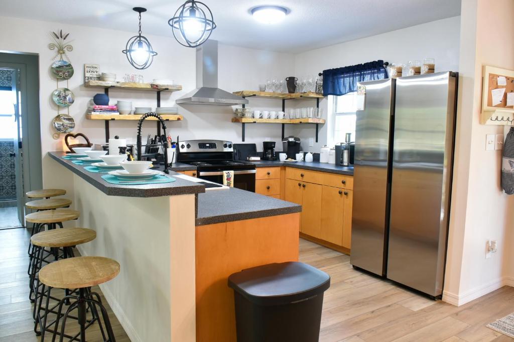 a kitchen with a refrigerator and a counter with stools at Luxurious Farm House 63 Acres in East Palatka