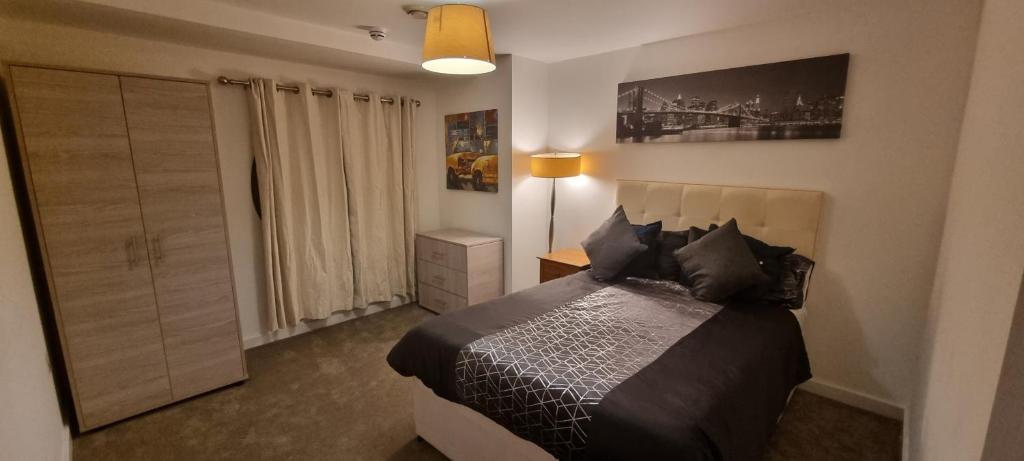 sypialnia z łóżkiem i lampką w obiekcie Paramount nest w mieście Swindon