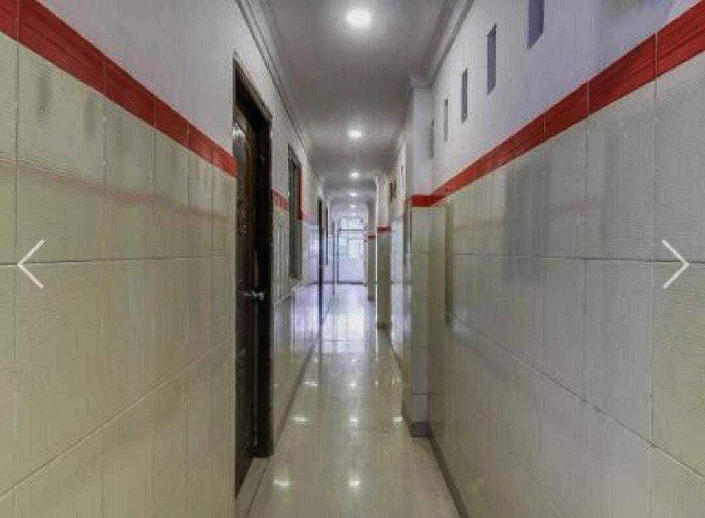 un pasillo vacío con rayas rojas y blancas en las paredes en Flagship Mak Residence, en Shamshabad