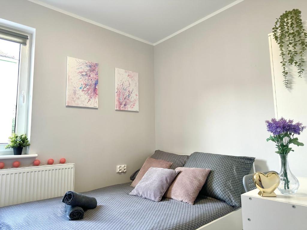 a white room with a couch with pink pillows at MMRent Pink Fusion Room in Gdańsk