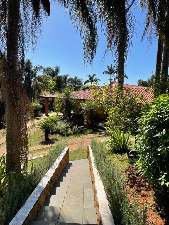 un giardino con palme e un vialetto di Espaço Casa Dona Dina a Campo Limpo