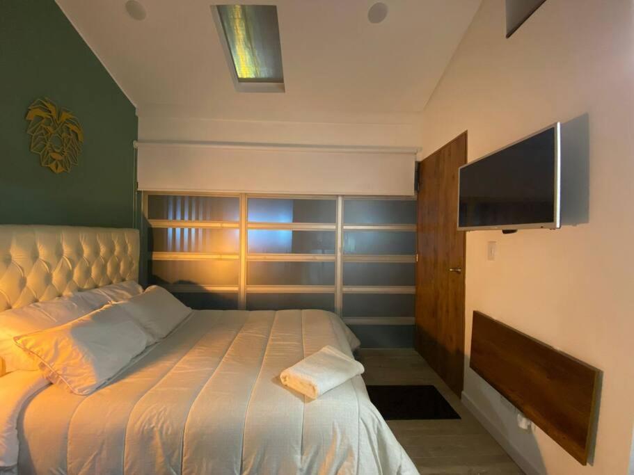 a bedroom with a bed and a flat screen tv at Acogedor Loft en Bogotá in Bogotá