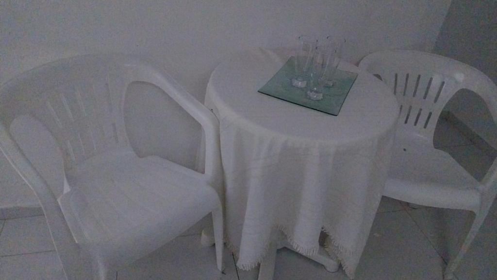 una mesa con dos sillas y un mantel blanco. en Açaí da Gema., en Belém