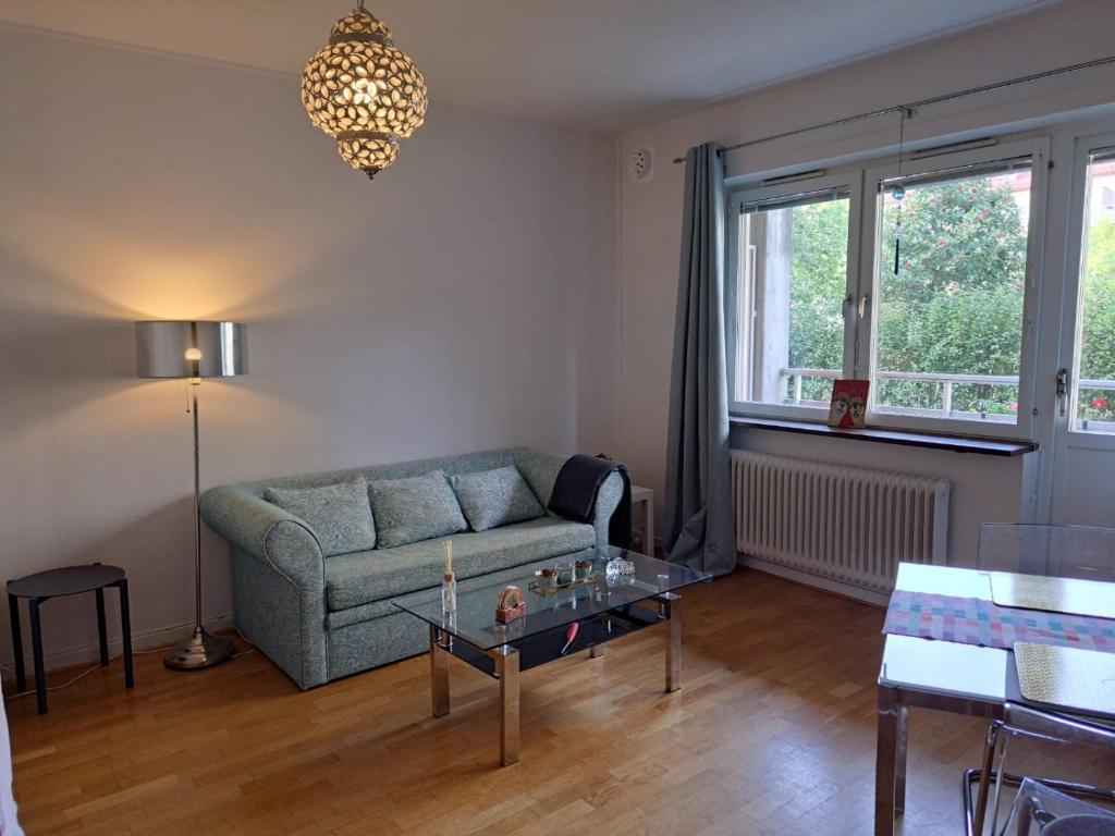 een woonkamer met een bank en een tafel bij Lägenhet nära grönområde in Malmö