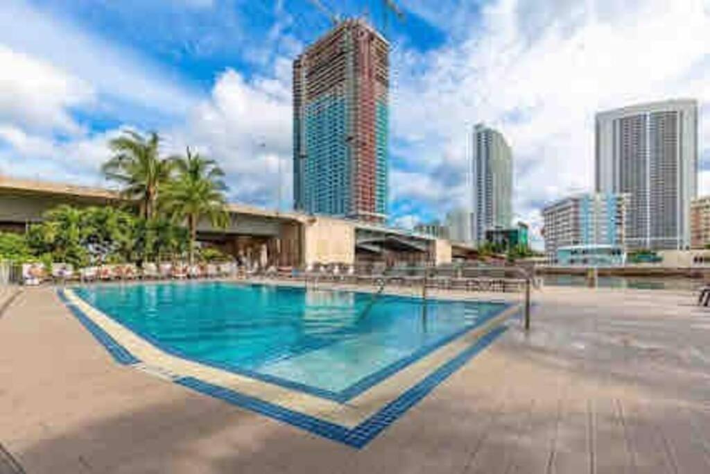 a swimming pool with a city skyline in the background at Beachwalk Resort & Condos in Hallandale Beach