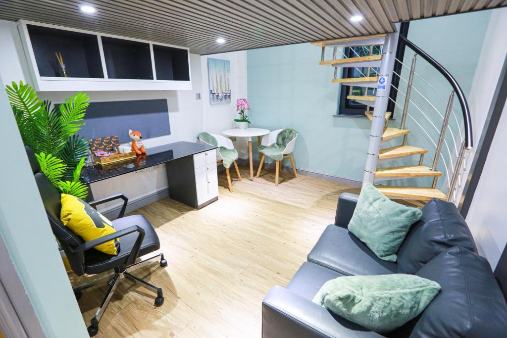 un soggiorno con scala, divano e tavolo di A101 Comfy Stylish Loft a Coventry