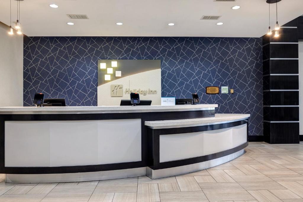 vestíbulo del hotel con mostrador de recepción y pared azul en Holiday Inn Houston Downtown, an IHG Hotel, en Houston