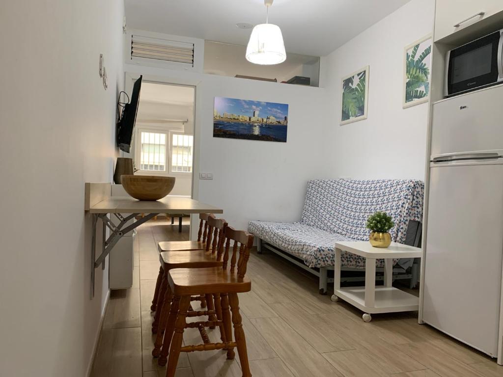 un soggiorno con un divano, un tavolo e delle sedie di Green Beach Las Canteras a Las Palmas de Gran Canaria