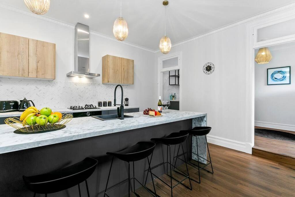 a kitchen with a counter with a bowl of fruit on it at EDW19 - Stylish 2-Bed, 2-Bath Townhose in Drummoyne in Sydney