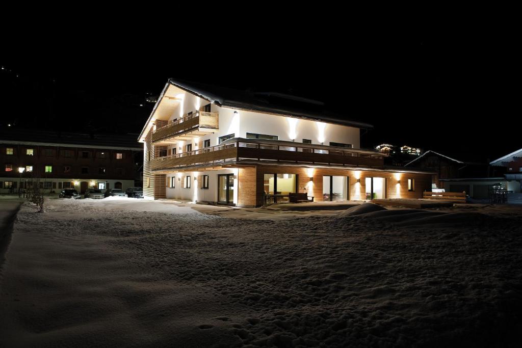 un edificio illuminato nella neve di notte di Das Tannberg a Lech am Arlberg