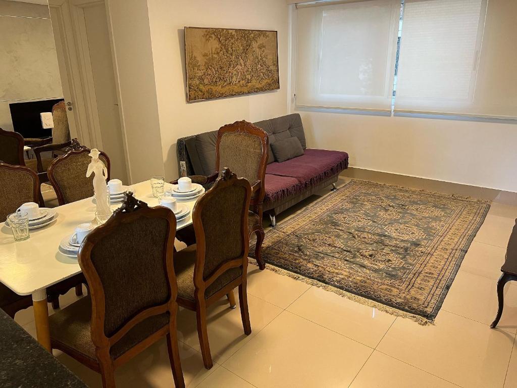 uma sala de estar com uma mesa e um sofá em Locking's Lourdes 13 em Belo Horizonte
