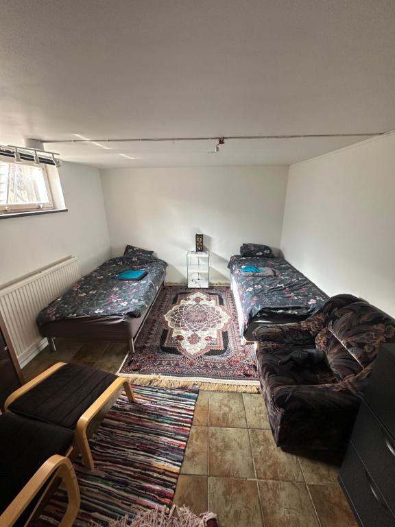 sala de estar con 2 camas y sofá en Room A, en Malmö