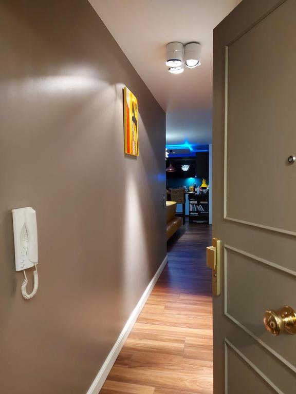 un couloir avec une porte et un téléphone sur un mur dans l'établissement Stade de France Chambre d'Hôte by RESERVATI HOME, à Saint-Denis