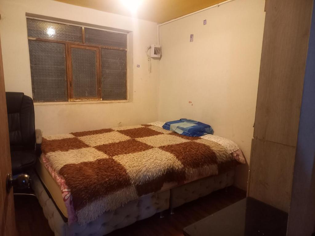 een slaapkamer met een bed in een kamer met een raam bij MyD in Cuzco