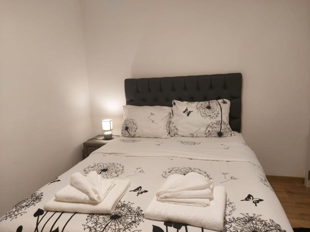a bedroom with a bed with a black and white bedspread at Maison Nasko in Dinant