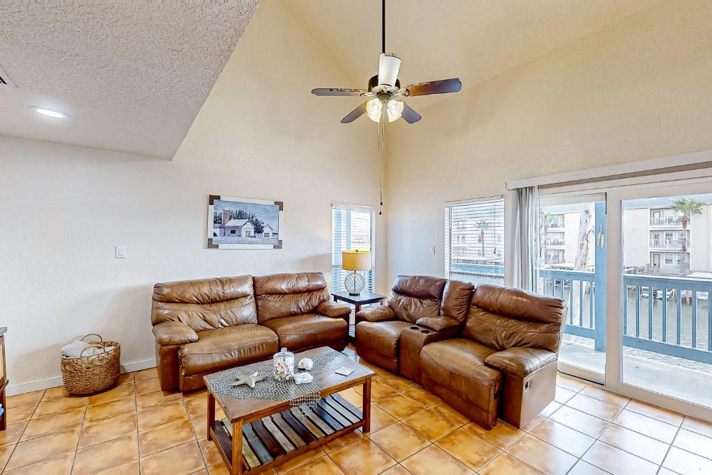 a living room with leather furniture and a ceiling fan at Ladyfish Landing in Padre Island