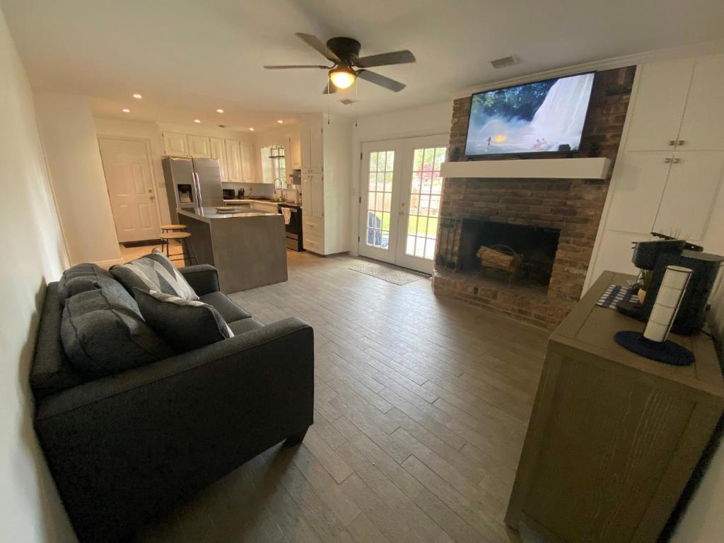 uma sala de estar com um sofá e uma televisão de ecrã plano em Spacious Ranch Home Near Airport em Pensacola