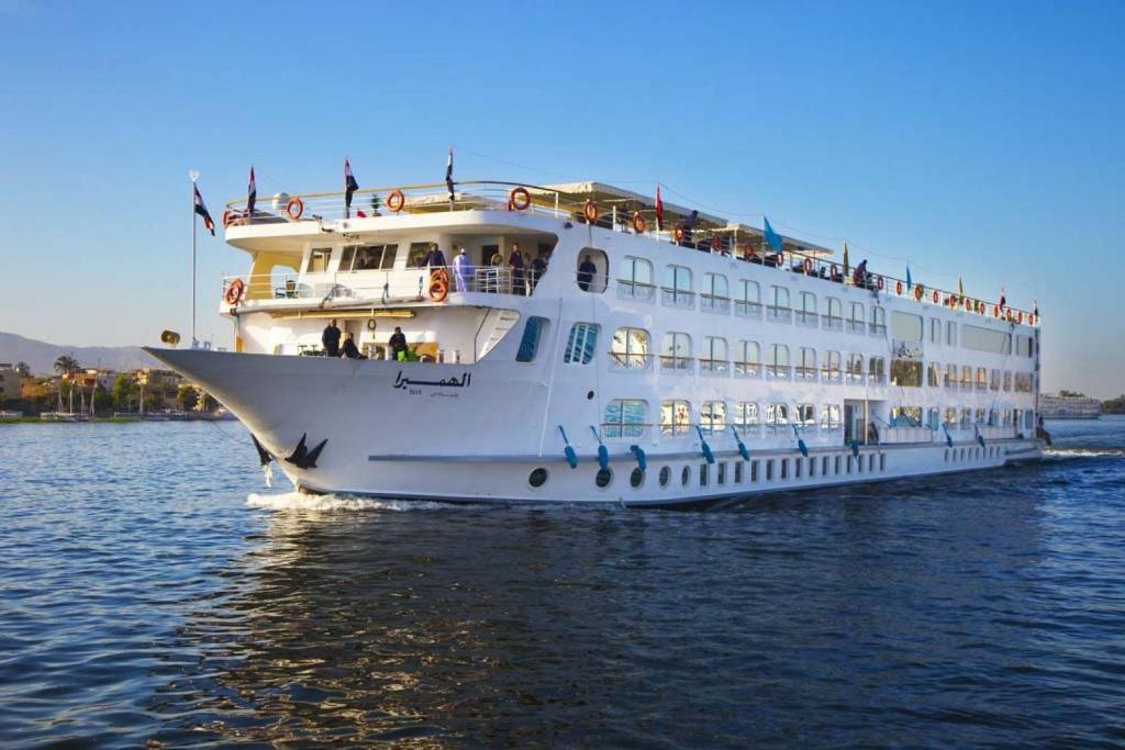 a large white cruise ship in the water at Upper Sky Tours 5 Stars Nile Cruises Sailing From Luxor To Aswan Every Saturday & Monday For 4 Nights - From Aswan Every Wednesday and Friday For Only 3 Nights With All Visits in Luxor