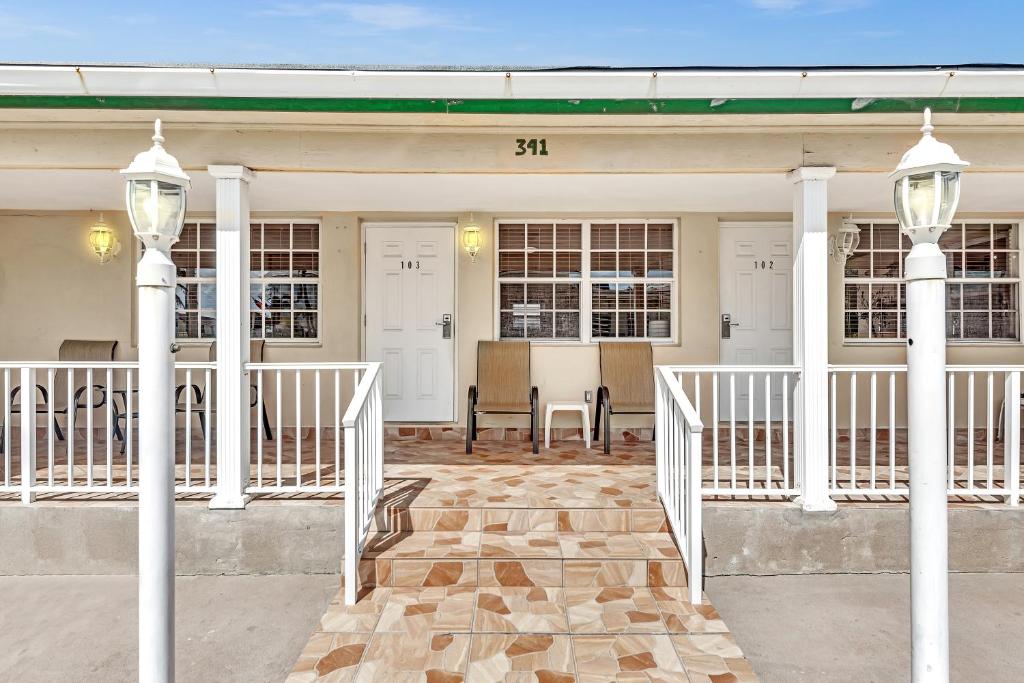 a front porch of a white house with two lights at The Sunrise in Hollywood