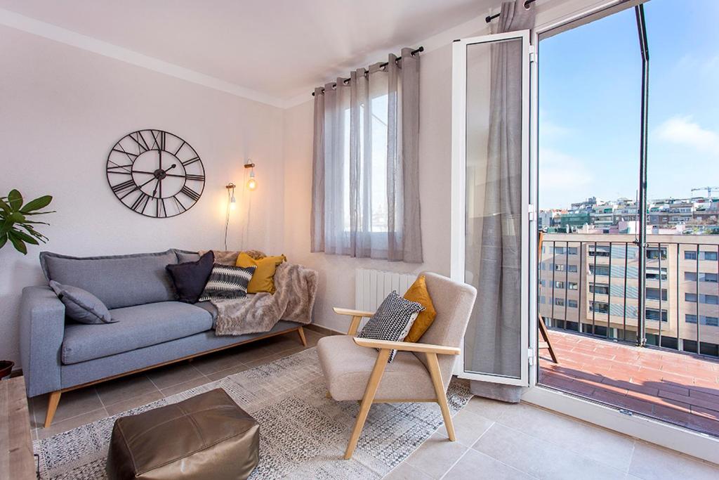sala de estar con sofá y ventana grande en Stay U-nique Apartments Fira BCN III, en Hospitalet de Llobregat